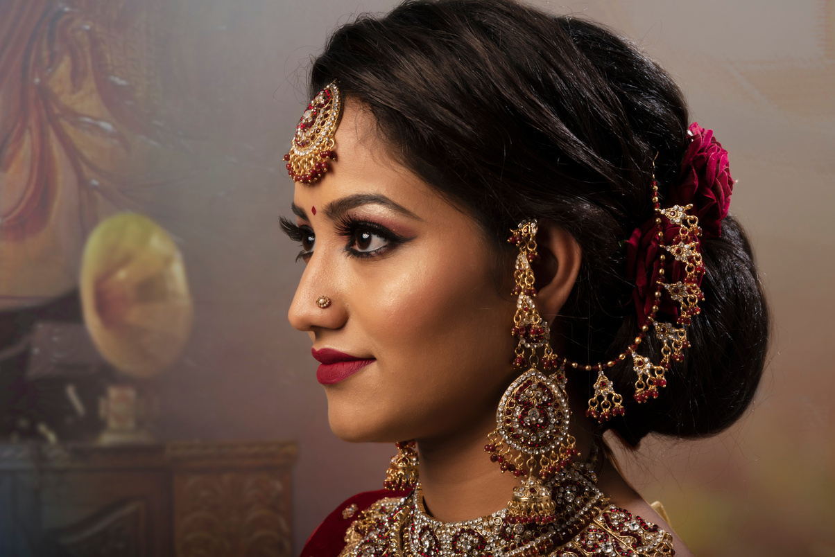 Young Indian woman in bridal wear, jewelry and make-up