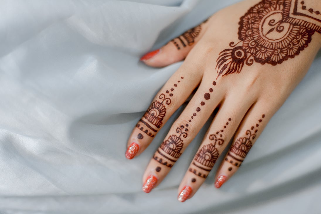 Close up of hands with intricate henna design