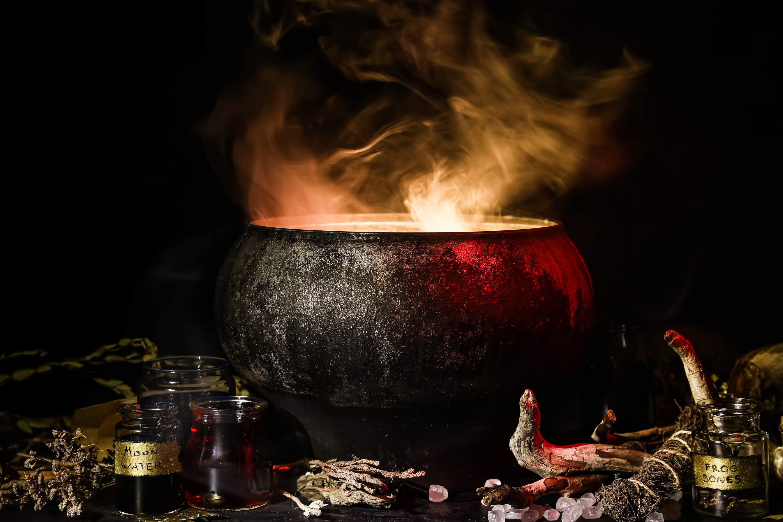 Witch's Cauldron with Potion and Different Magic Attributes for Ritual on Dark Background